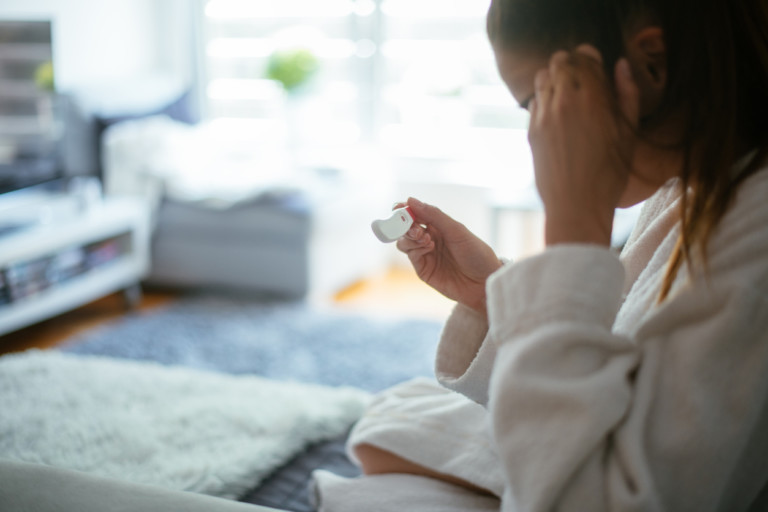 Woman looking at home pregnancy test visuel tdr